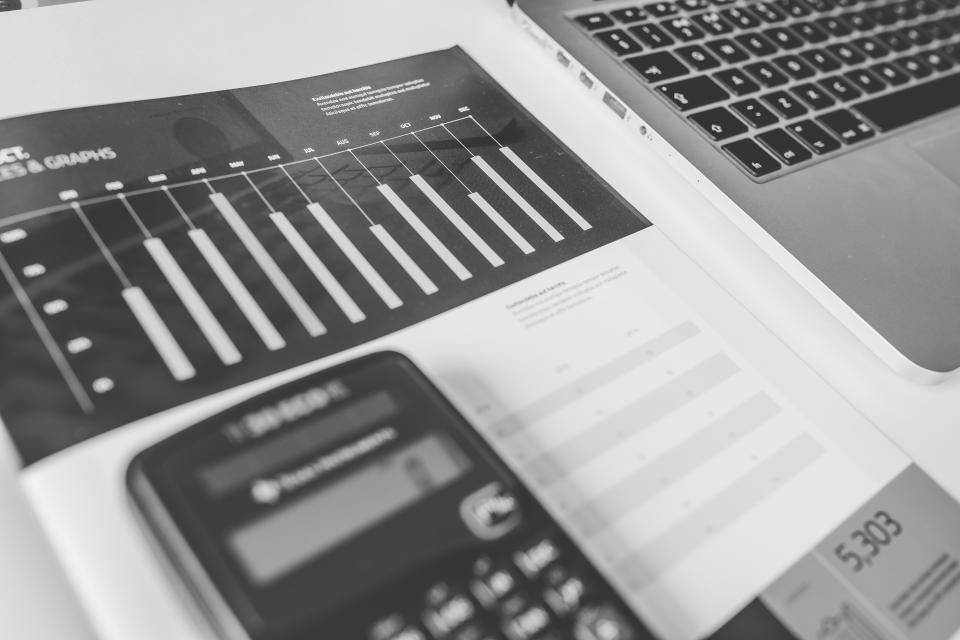 Un rapport imprimé montrant un graphique en barres, posé sur un bureau à côté d'une calculatrice